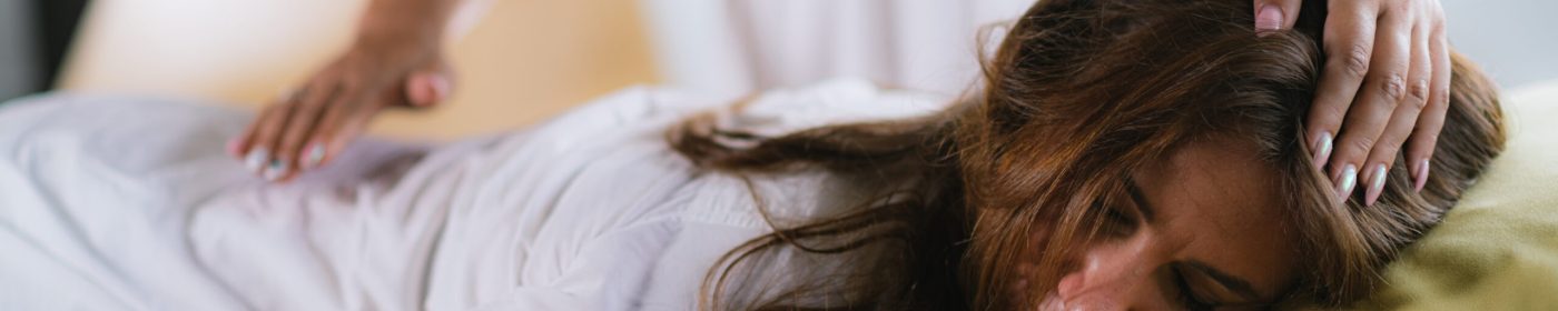 Obrazek przedstawiający senność po masażu - panią leżącą na stole do masażu, powoli przysypiającą.